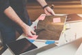 Close-up of catalog of finishing materials in male hands. Man standing near table, leafing through book Royalty Free Stock Photo