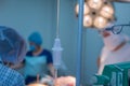 Close-up of dropper dispenser in the operating room. Against the backdrop of a defocused team of children`s surgeons, work in the