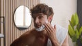 Close up Caucasian bearded male funny man guy looking at camera beauty routine morning hygiene procedure bathroom apply Royalty Free Stock Photo