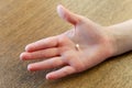 Close-up of a caucasian boy hand holding lost milk tooth on wooden background Royalty Free Stock Photo