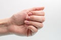 Close-up of a Caucasian female hand with natural unpolished nails, overgrown cuticle on a white background