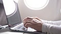 CLOSE UP: Caucasian female`s fingers type on sleek silver and black laptop keyboard during a long flight.