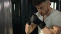 Close up Caucasian fighter boxer man training box fight punching use sport equipment. Strong motivated sportsman hitting