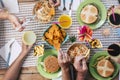 Close up of caucasian friends hands taking fast food hamburger and frech fries from the table - group of unrecognizable people