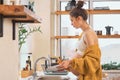 Beautiful young pregnant woman washes the dishes Royalty Free Stock Photo