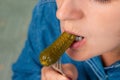 Close-up of a Caucasian woman biting a pickled cucumber Royalty Free Stock Photo
