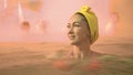 Close up caucasian woman in a swim in hot saline mineral water bath at a traditional spa outdoor with soft magic pink Royalty Free Stock Photo