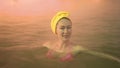 Close up caucasian woman in a swim in hot saline mineral water bath at a traditional spa outdoor with soft magic pink Royalty Free Stock Photo