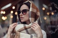 Close up of Caucasian young beautiful stylish woman in sunglasses and motley scarf outdoor. Royalty Free Stock Photo