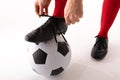 Close-up of caucasian young female player tying shoe lace while standing with foot on soccer ball Royalty Free Stock Photo