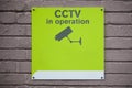 Close-up of CCTV in operation sign on wall