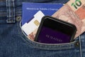 Close up of cell phone in pocket of pants with positive bank balance. Portfolio of work and social security. Real banknotes.