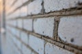 Close-up of the cement between bricks of the house. Sunset. Gray brick building. Close-up of the seam between the bricks