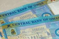 A close up of the Central Bank of Oman 20 Riyal bills of cash, the currency of the Oman notes spread out on a semi white