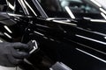 Ceramic coating application on glossy black car paint during professional car detailing process Royalty Free Stock Photo