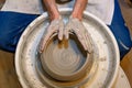 close up of ceramist woman hands working and shaping clay on the lathe or potter's wheel inside a pottery workshop