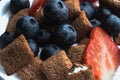 Close up Cereal bowl with milk, blueberries and strawberries. Royalty Free Stock Photo