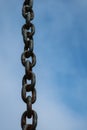 Close-up of a chain hanging with a cloudy blue sky Royalty Free Stock Photo