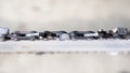 Close-up of a chainsaw chain on a tire on a blurred background, top view Royalty Free Stock Photo