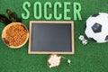 Chalk board, snacks and football on artificial grass
