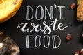 Close up of a chalkboard with Don`t waste food lettering and rotten fruits. Selective focus Royalty Free Stock Photo