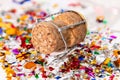 Close-up of a champagne cork with its cage on a background of multicolored confetti. Cork has a date of 2021. Selective focus Royalty Free Stock Photo