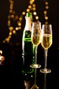 Close up of champagne in flutes with bottle reflecting on glass table Royalty Free Stock Photo