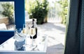Close up of champagne glasses on transparent table. Bottle of wine and ice cooler Royalty Free Stock Photo