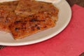 Close-up of charcoal-grilled Chinese bakkwa jerky made from chicken meat on a white saucer, with a New Year red packet envelope