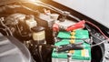 Close up Charging car battery with electricity through jumper cables. Royalty Free Stock Photo