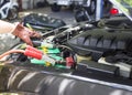 Close up Charging car battery with electricity through jumper cables Royalty Free Stock Photo