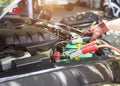 Close up Charging car battery with electricity through jumper cables Royalty Free Stock Photo