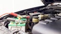 Close up Charging car battery with electricity through jumper cables Royalty Free Stock Photo