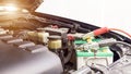 Close up Charging car battery with electricity through jumper cables Royalty Free Stock Photo