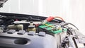 Close up Charging car battery with electricity through jumper cables Royalty Free Stock Photo