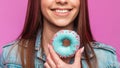 Close up of charming cute smile with the teeth young woman. Positive girl model beautiful smiles and holds in hand sweet donut in