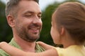 Close up of cheerful dad looking at his little girl, holding her while spending time together outdoors on a warm day Royalty Free Stock Photo