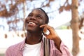 Close up cheerful male student talking on cell phone outside Royalty Free Stock Photo