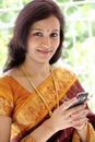 Cheerful traditional woman texting on cellphone