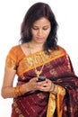 Cheerful traditional woman texting on cellphone