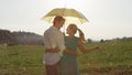 CLOSE UP: Cheerful young Caucasian couple in love enjoying fresh summer rain Royalty Free Stock Photo