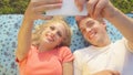 CLOSE UP Cheerful young couple lying on a blanket and taking selfies during date Royalty Free Stock Photo
