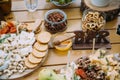 Close-up cheese bar of several kinds of cheese, snacks, honey, nuts decorated on wooden table at the wedding party