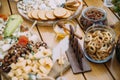 Close-up cheese bar of several kinds of cheese, snacks, honey, nuts decorated on wooden table at the wedding party