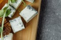 Close-up of a cheese plate. 4 types of cheese, soft white brie cheese, camembert, semi-soft briques, blue, roquefort, hard cheese Royalty Free Stock Photo