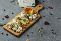 Close-up of a cheese plate. 4 types of cheese, soft white brie cheese, camembert, semi-soft briques, blue, roquefort, hard cheese Royalty Free Stock Photo