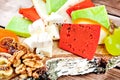Close up of cheese plate - various types of cheese, honey, grapes, dried apricots, nuts and figs on a wooden cut. Royalty Free Stock Photo