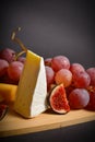 Close up of Cheeseboard platter with hard and soft mould cheese, grape and segmented fig on wooden boardcheese, platter,