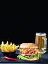 Close-up of Cheeseburger, fries, beer in a mug Royalty Free Stock Photo