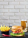 Close-up of Cheeseburger, fries, beer in a mug Royalty Free Stock Photo